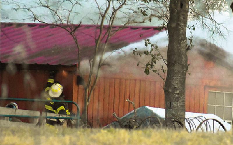 FIREFIGHTERS WORK THE scene of this fire on SH 36 North.