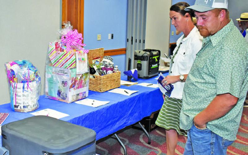 THOSE ATTENDING THE Law Enforcement Officers Appreciation Banquet look over these auction items prior to the program. Tribune photo by Roy Sanders