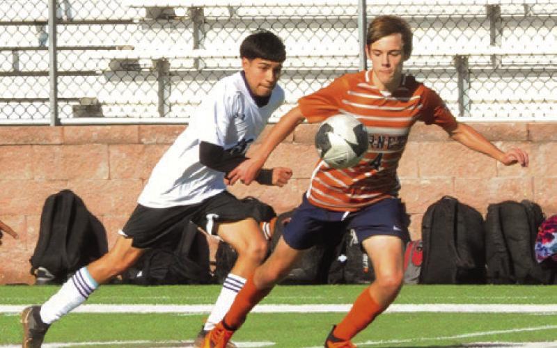 CALDWELL’S MARK LASUER races a Florence player for possession of the ball during their game last Thursday afternoon in Cameron at the Yoe Invitational Tournament. -- Tribune photo by Denise Squier