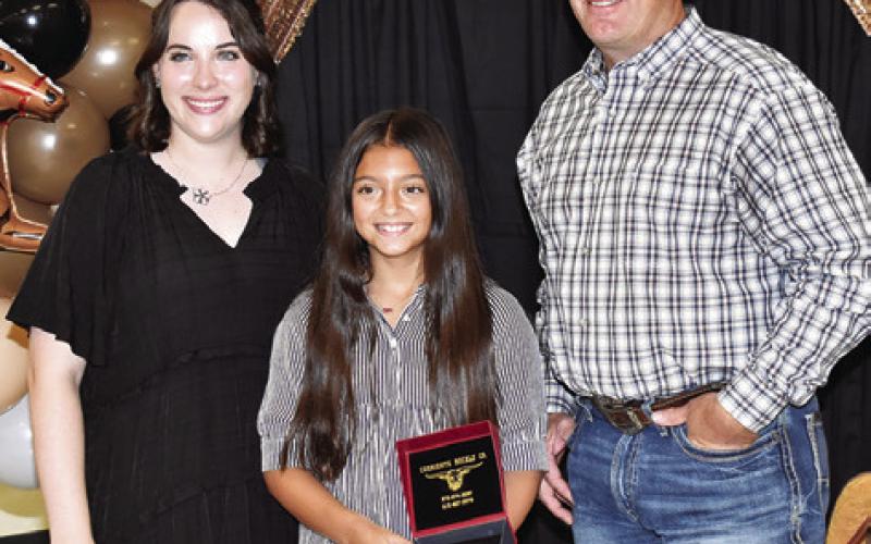 SAVANNAH FAUST IS presented the Silver Star by Megan Rogers and Steve Canon. Tribune photo by Roy Sanders