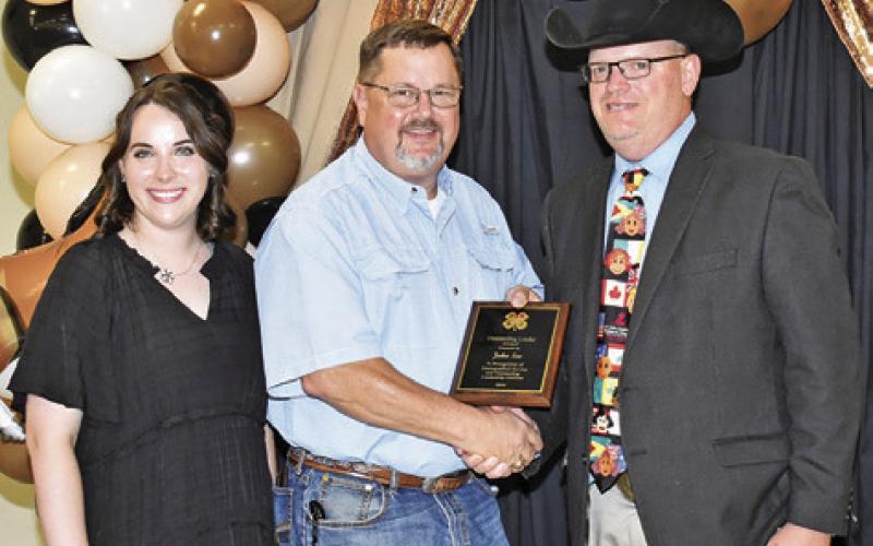 JOHN SEE IS presented the Outstanding Club Leader Award by Megan Rogers and John Grange. Tribune photo by Roy Sanders