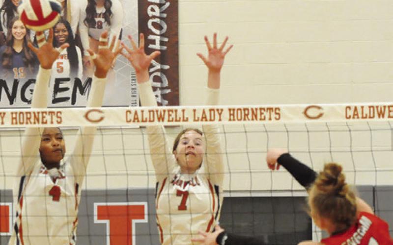 TYNIAH JOHNSON AND LYDIA Giese attempt to block a hit from BVCHEA’s Cali Engram during the Lady Hornets’ match against the Lady Mustangs on Friday night in Hornet Gym. Tribune photo by Denise Squier