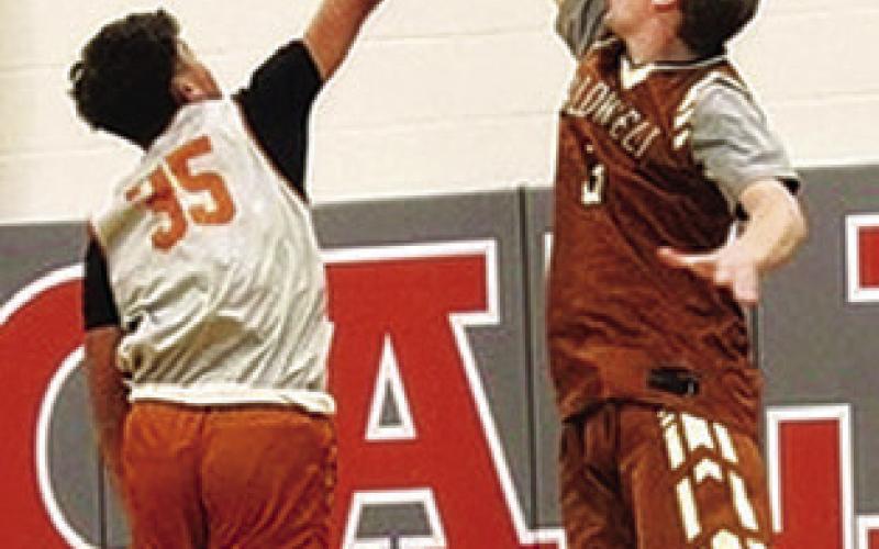 CALDWELL’S CLAYTON FRAYLEY takes a shot as Harrison Novak defends in the alumni scrimmage in Caldwell on Tuesday, Nov. 11.