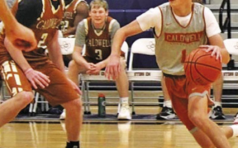 CALDWELL’S LOGAN COLBERT, right, dribbles the ball as alumni Ryan See defends in the Nov. 11 almuni scrimmage in Caldwell.