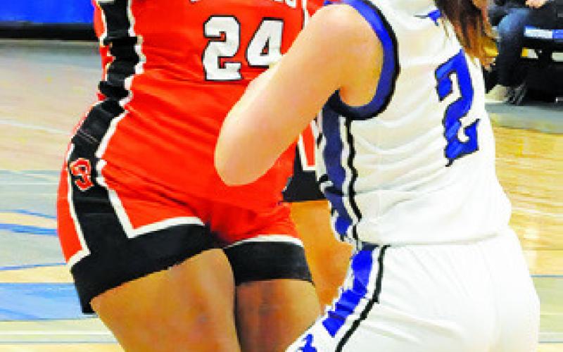 KEIRA MOORE LOOKS for help while being defended by a Mumford player during the Somerville-Mumford game Friday night. Tribune photo by Denise Squier