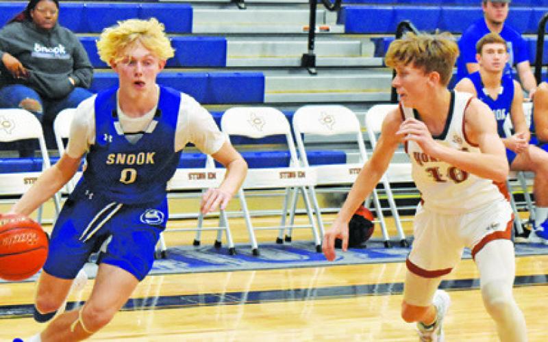 LIAM ZEQUEIRA OF Snook dribbles the ball as Caldwell’s Travis Cunningham defends. Caldwell won 62-37. -- Tribune photo by Roy Sanders