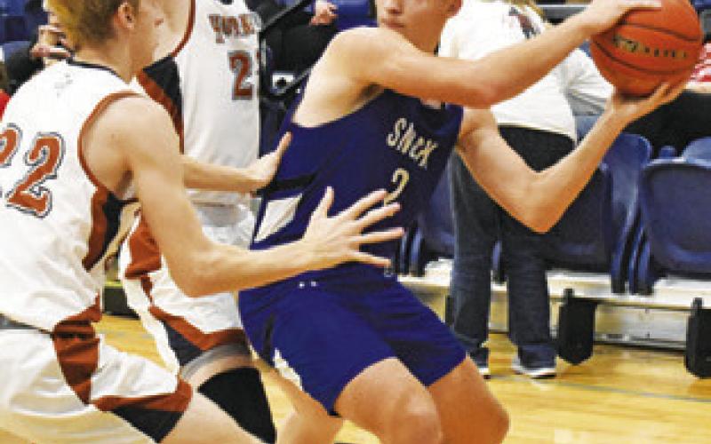 SAM SMITHERMAN of Snook prepares to pass the ball as Caldwell’s Daniel Cowan and Harrison Novak play defense.