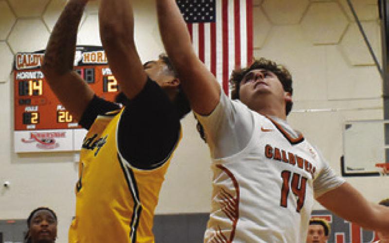 JOHN FRYREAR of Caldwell reaches high for this rebound against Academy Tribune photo by Roy Sanders