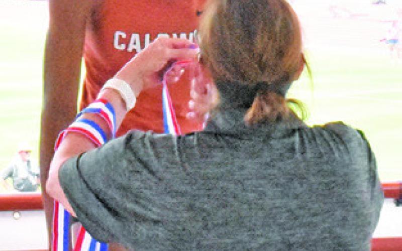 CALDWELL’S JAE Mathis receives her bronze medal during the awards ceremony at the UIL State Track &amp;amp; Field Meet last Thursday.