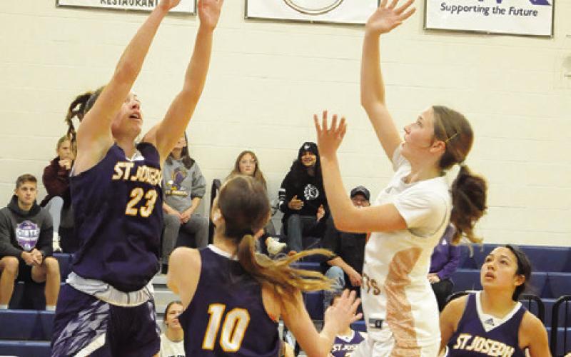 CALDWEL L ’ S LYDIA HICKS takes a shot over a couple of St. Joseph defenders during the Caldwell-St. Jo’s game last Friday. Tribune photo by Denise Squier