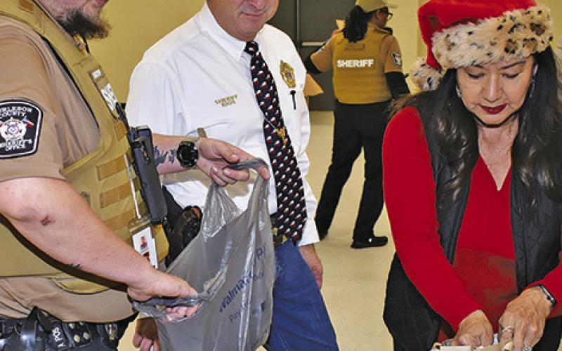SHERIFF BILL RIOS and his wife Irma help with presents during Shop With A Cop.