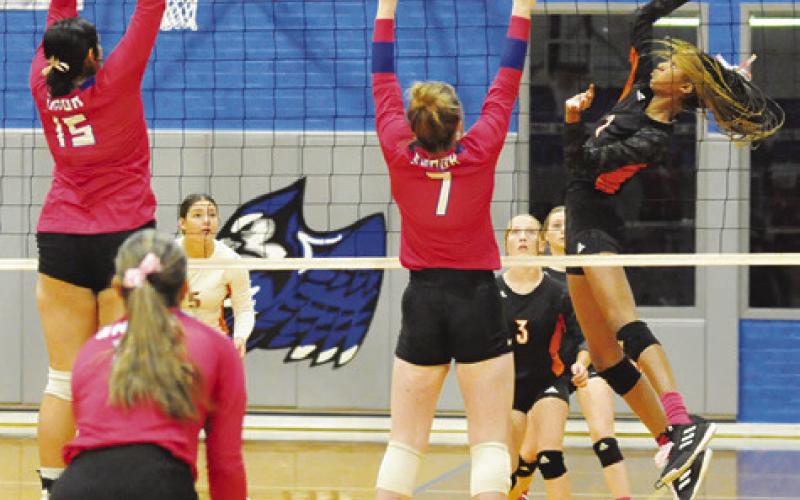 SOMERVILLE’S KARYS ELLIS gets a kill by hitting the ball between Snook’s Karla Lara and Kiley Price during a district volleyball match in October 2024 in Snook. Tribune photo by Denise Squier