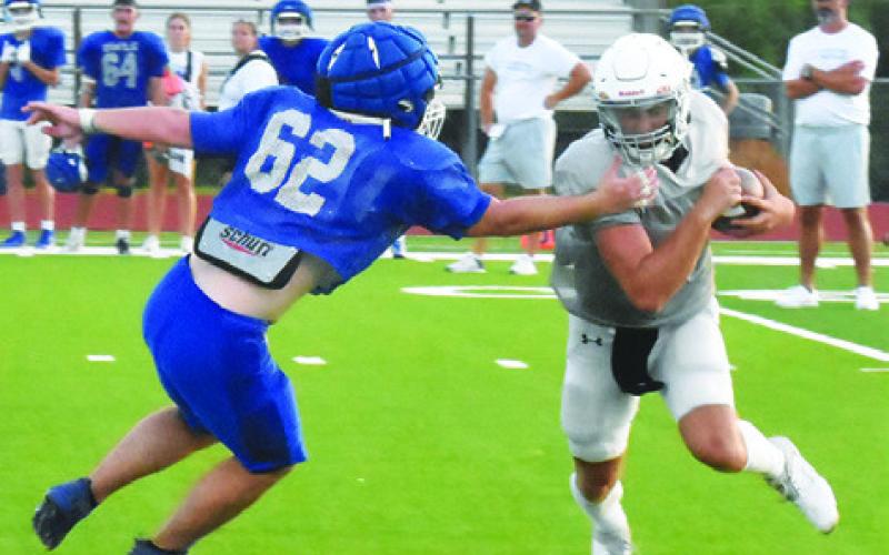 CALDWELL QUARTERBACK COY Becka gets around this Anderson-Shiro defender in the scrimmage. -- Tribune photo by Roy Sanders