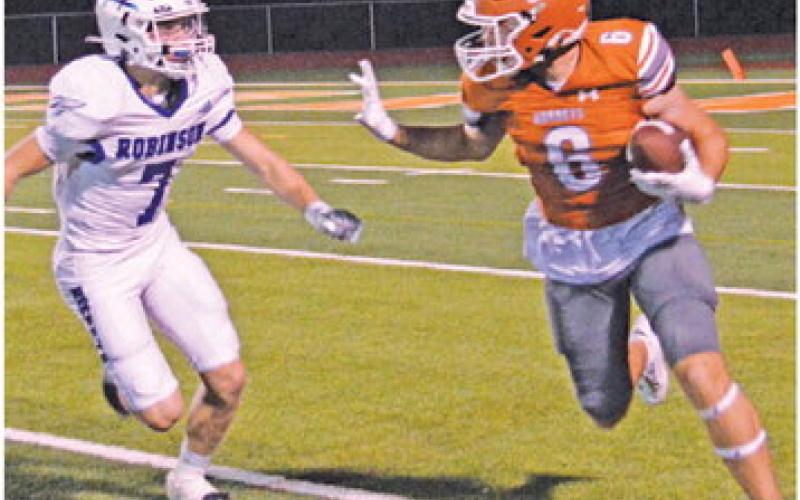 JAMIN WHITE CARRIES the ball after a reception against Robinson.