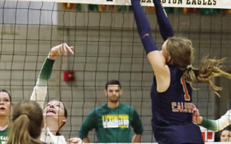 LUCY FERGUSON goes up to block the ball with the Lady Hornets ready on defense. Photo courtesy of Casey Faske