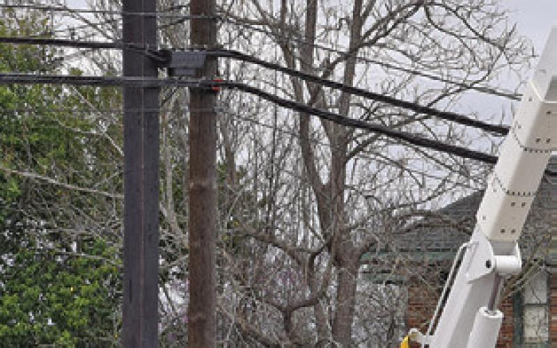 ARDENT SERVICES crew members work on these electrical lines in Hill Street. Tribune photo by Roy Sanders