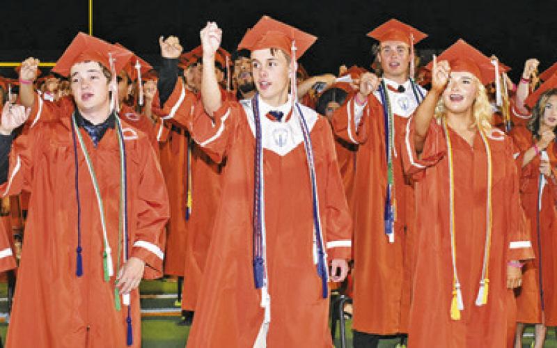 CALDWELL HIGH SCHOOL GRADUATES sing the school song at the Friday commencement.