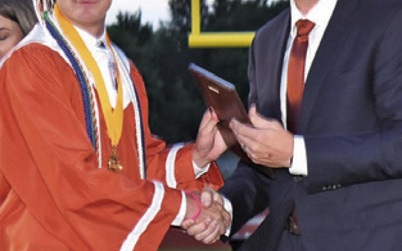 SALUTATORIAN COLBY Maresh is congratulated by Caldwell Superintendent Dr. James Barton at the Friday commencement.