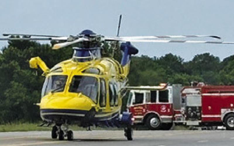 A HELICOPTER LANDS at the scene of this fatal accident on Saturday, June 20, on State Highway 21 West just past the county line.