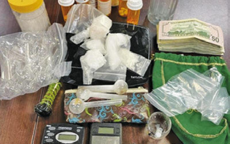DRUGS, CASH and a weapon are displayed after the Thursday, June 15, arrests.