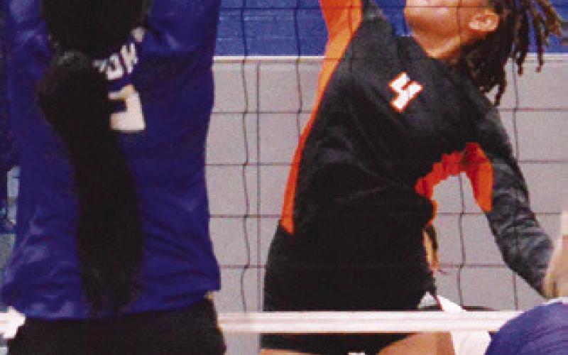 GABBY JACKSON prepares to hit the ball while Karla Lara attempts to block. Snook won Friday’s rivalry match.