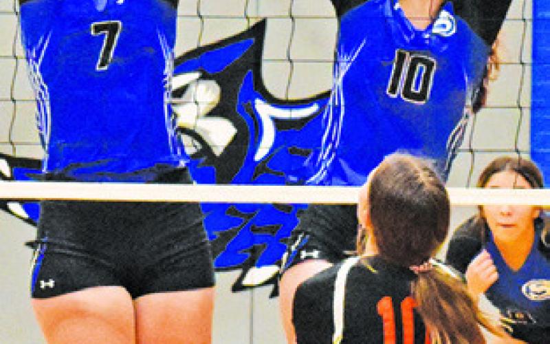 ALEXIS MACIK and Payton Sodolak reach to block a hit during Friday’s Lady Jay win over Buckholts 25-20, 25-19, 25-9.