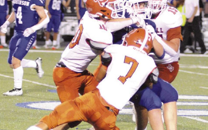 THE HORNET DEFENSE, including E.J. Rogers, Dylan Errington and Preston Supak bring down this Robinson player.