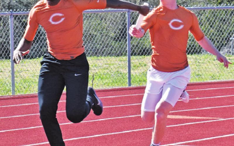 CALDWELL’S CONNOR LEE passes the baton to Jamar Hewitt during a boys’ relay race at last week’s Happy Skrabanek Relays in Caldwell.