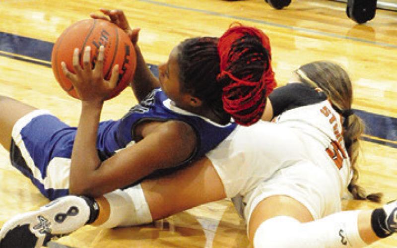 SNOOK’S SHAYONA ALLEN and Caldwell’s Ashlyn Kellum fight on the floor for possession of the ball during their game on Saturday.