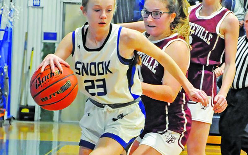 DAKOTA KIENOW dribbles down the baseline after a rebound during the Snook-Fayetteville game last week in Snook.