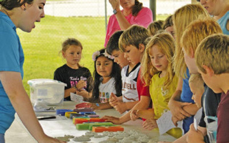 MEGAN ROGERS FROM Texas A&amp;amp;M AgriLife shows children at the Harrie P. Woodson Memorial Library’s “Hot on the Trail” event molds of different animal tracks. Tribune photo by Kimberly Hutcheson