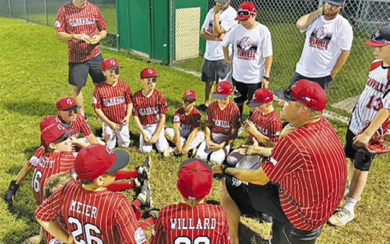 THE DEANVILLE REDS 10U ALL-STARS get a pep-talk from their coach during the PONY League’s Austin Section 10U Baseball Tournament.
