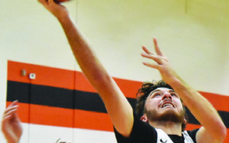KASON ROHRBACH moves past this St. Joseph defender for a layup shot. Tribune photo by Roy Sanders