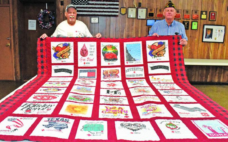 SHERWOOD LUCKO JOINS Franklin Karasek in displaying this quilt representing T-shirts he has earned through the years as an American Red Cross blood donor. See story inside.