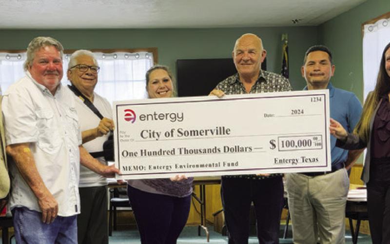 SOMERVILLE CITY OFFICIALS ACCEPT this check for grant funding from Entergy at their Aug. 20 meeting. Pictured are, from left, Kenny Muhammad, regional customer service manager, Alderman Mark Sager, Alderman Delfino Orozco, Alderwoman Laura Hoover, Mayor Tommy Thompson, City Administrator Danny Segundo, Melissa Bochat, Entergy customer service manager, and new City Administrator David Resendiz.