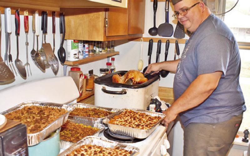 DAVID PALICKA HELPS prepare a community Thanksgiving dinner on Thursday at Stone Street Retirement Complex. The dinner was prepared by In God’s Hands Ministry and was well attended.