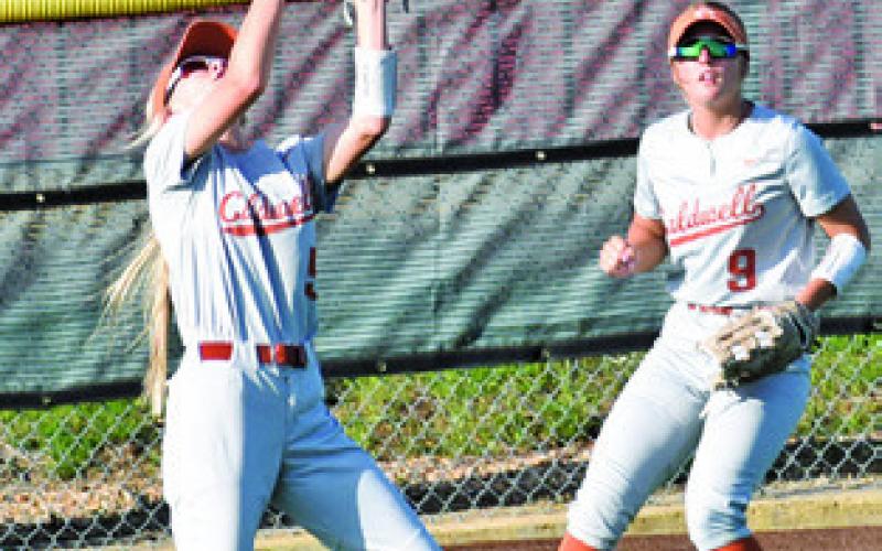 EMMA GREGORY prepares to catch a fly ball while Molly Meadows looks on during the Caldwell-Giddings game last Friday. Tribune photo by Roy Sanders