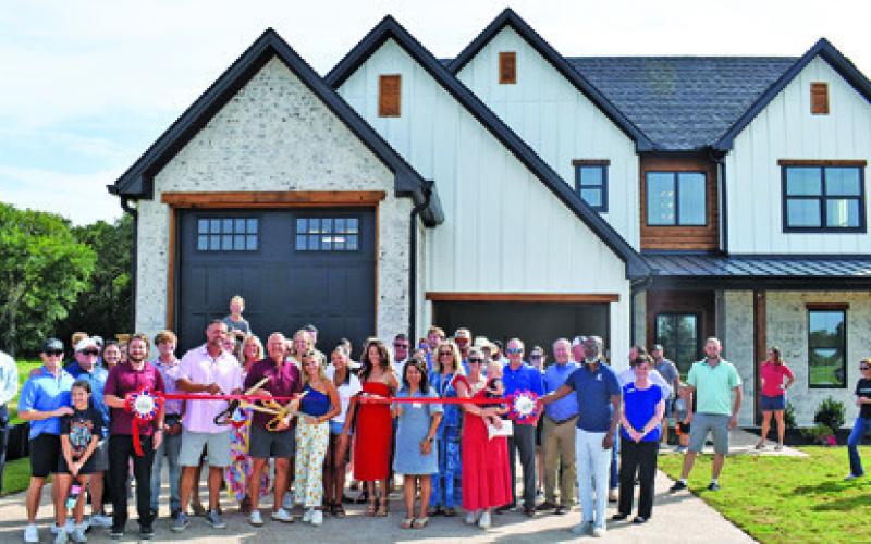 A RIBBON CUTTING IS held for The Reserve Subdivision in Somerville off Thornberry Drive on Wednesday, July 2. One home is completed, and another is under construction. Developers are planning a total of 145 homes in three to five years. They are beginning with the first of three planned phases, and city-required infrastructure for phase one is now complete.