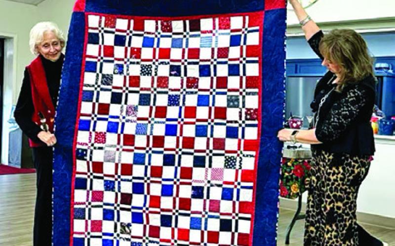 MEMBERS OF THE CREATIVE MEMORIES Quilt Guild sewed Quilts of Valor for veterans in the area, one block at a time, Sara Byman, left, quilted this beautiful Disappearing Four Patch quilt to be awarded to a veteran, with Bekki Campise, right, assisting in holding the quilt. The Creative Memories Quilt Guild meets at the Methodist Church on Fox Street in Caldwell, usually on the fourth Wednesday of the month. Photo courtesy of Barbara Behler