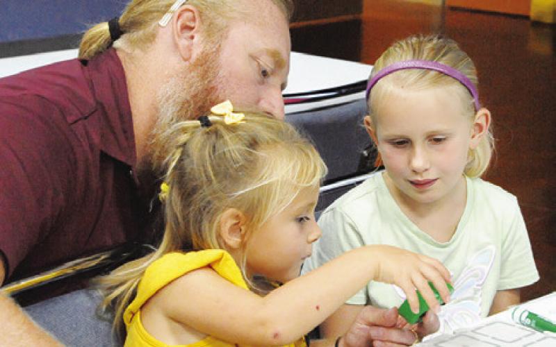 PEOPLE FROM THE TEXAS A&amp;amp;M University Department of Engineering helped local children program small, round robots during the Harrie P. Woodson Memorial Library “Spark” event last Thursday. Tribune photo by Denise Squier