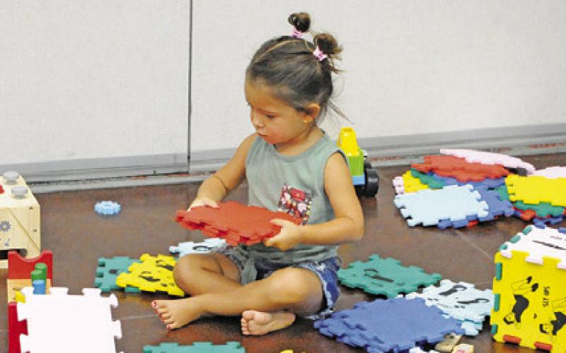 YOUNG CHILDREN WERE able to use their imagination to build objects with these tiles at last Thursday’s “Spark” event, hosted by the Harrie P. Woodson Memorial Library. Tribune photo by Denise Squier