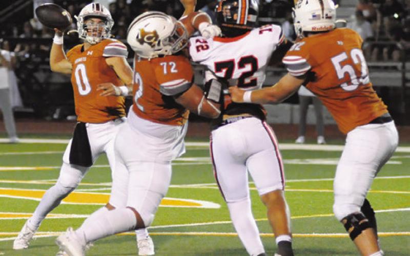 CALDWELL’S COY BECKA passes against Smithville while Preston Supak and Chase Clark block. Caldwell won 49-24. Tribune photo by Denise Squier
