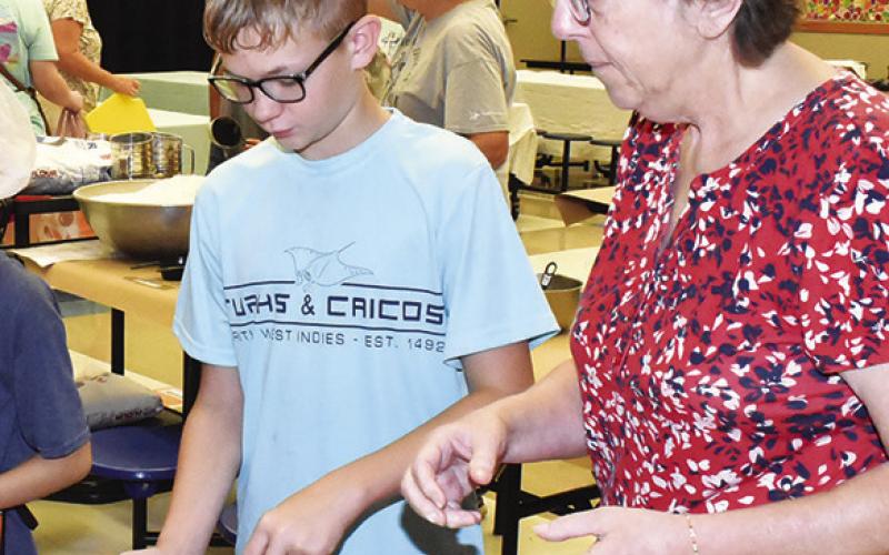 SHARON KOVAR helps Shane Keinow mix the kolache dough.