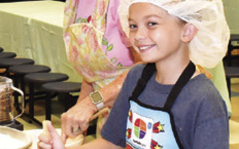 ROSE REDDING helps Poet Moltzer mix the kolache dough.