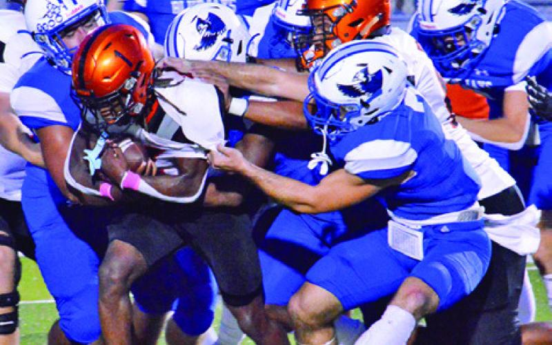 SNOOK’S DEFENSE SWARMS to tackle Somerville’s Herschel Conway last Friday in Snook. -- Tribune photo by Roy Sanders