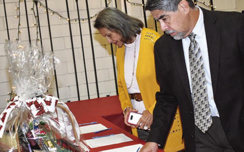 ROY AND BETTYE Gomez look over the silent auction items on Thursday, Dec. 5, at “A Historical Christmas” as presented by the Somerville Historical Society and Museum in Somerville.
