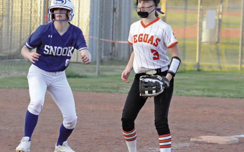 SNOOK’S KYLIE PRICE and Somerville’s Aubrey Flencher watch the batter at home plate during the Snook-Somerville game last Tuesday night in Somerville. -- Tribune photo by Denise Squier