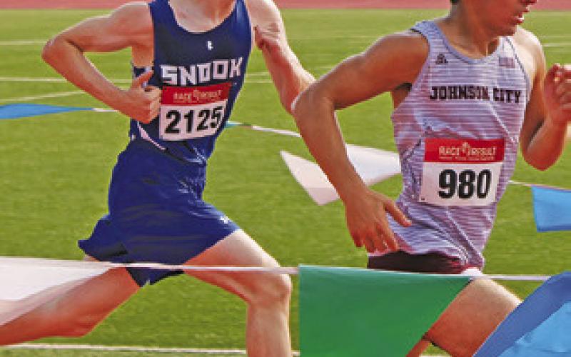 SNOOK’S ETHAN JANAC runs to pass Antonio Perez of Johnson City during the boys race at the UIL Class 2A Region 4 Cross Country Meet.