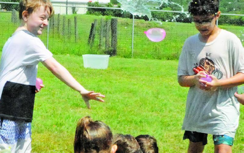 AREA CHILDREN ENJOYED being on the throwing and receiving end of a water balloon free-for-all during the Harrie P. Woodson Memorial Library’s special event last week at Davidson Creek Park.