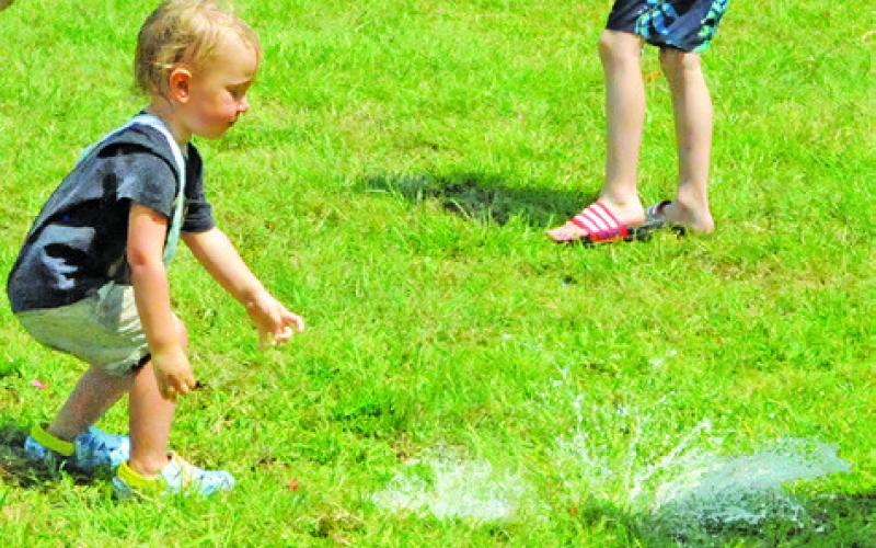 CHILDREN OF ALL AGES enjoyed busting water balloons during the Harrie P. Woodson Memorial Library’s special event last Thursday at Davidson Creek Park. -- Tribune photo by Denise Squier